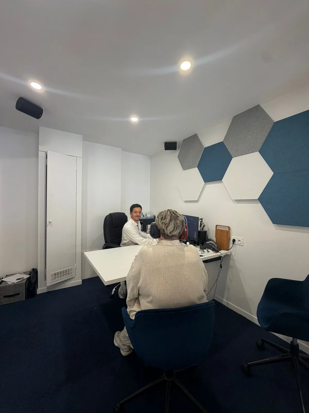 Cabine de bilan auditif : Maxime Douillet réalise un test avec une patiente
