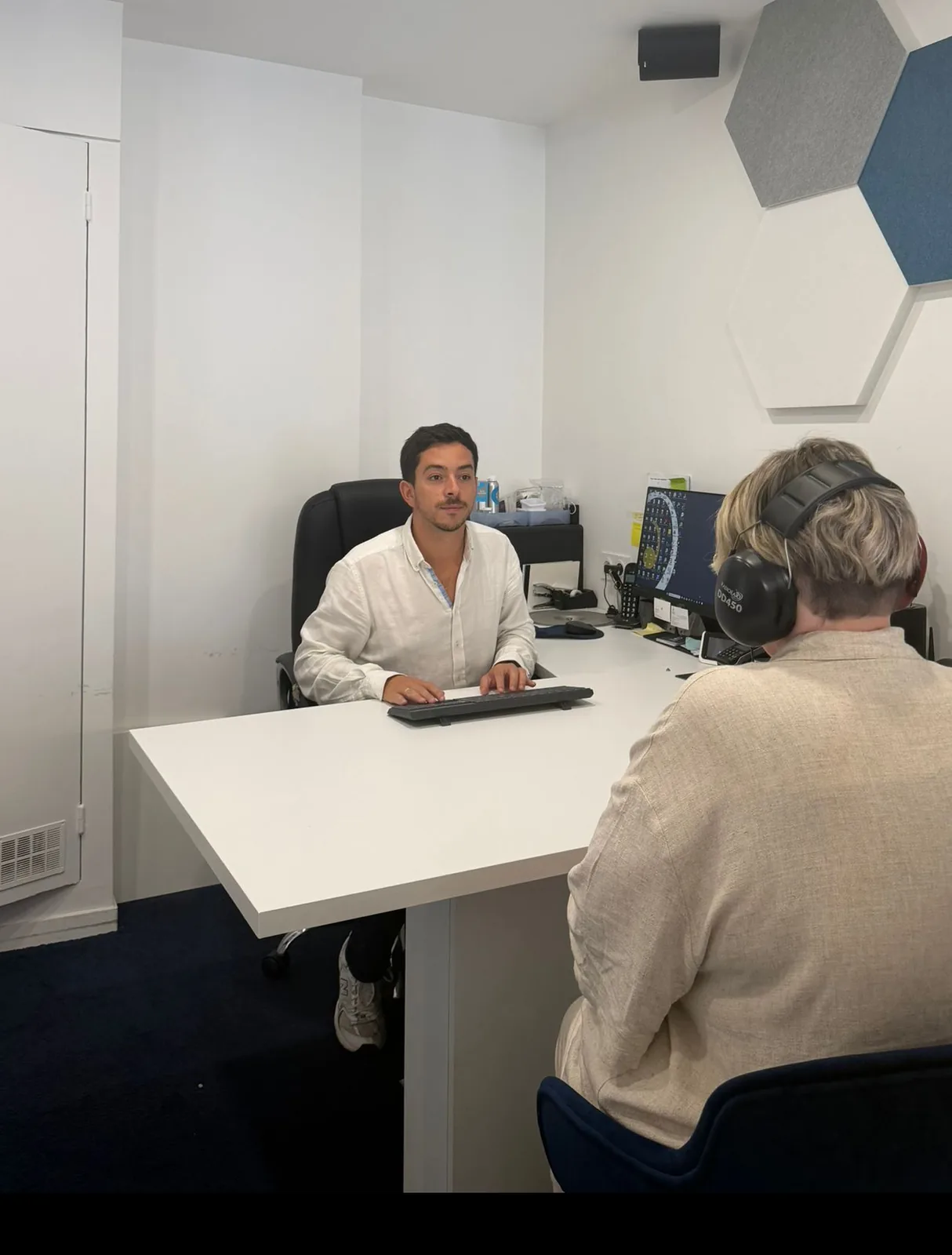 Maxime Douillet en consultation avec une patiente dans la cabine de bilan auditif